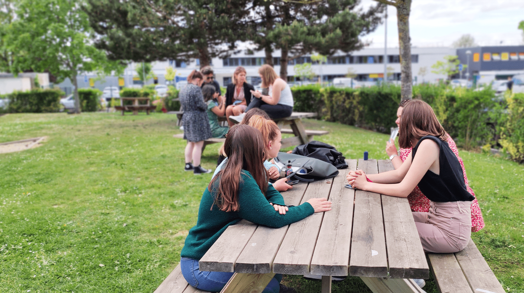 Groupe d'étudiants assis autour d'une table en plein air